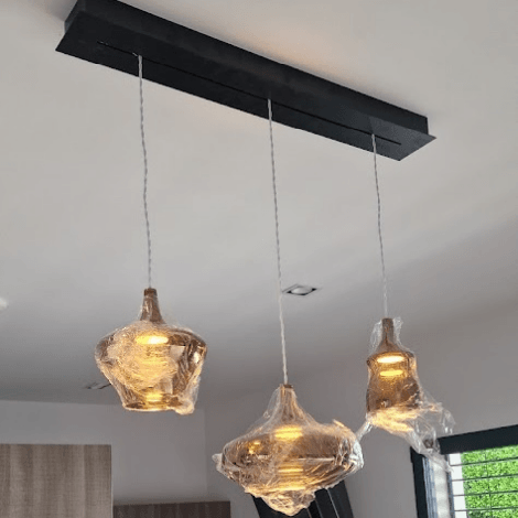 Luminaire moderne posé au plafond d'un salon, apportant une lumière douce et élégante à la pièce.